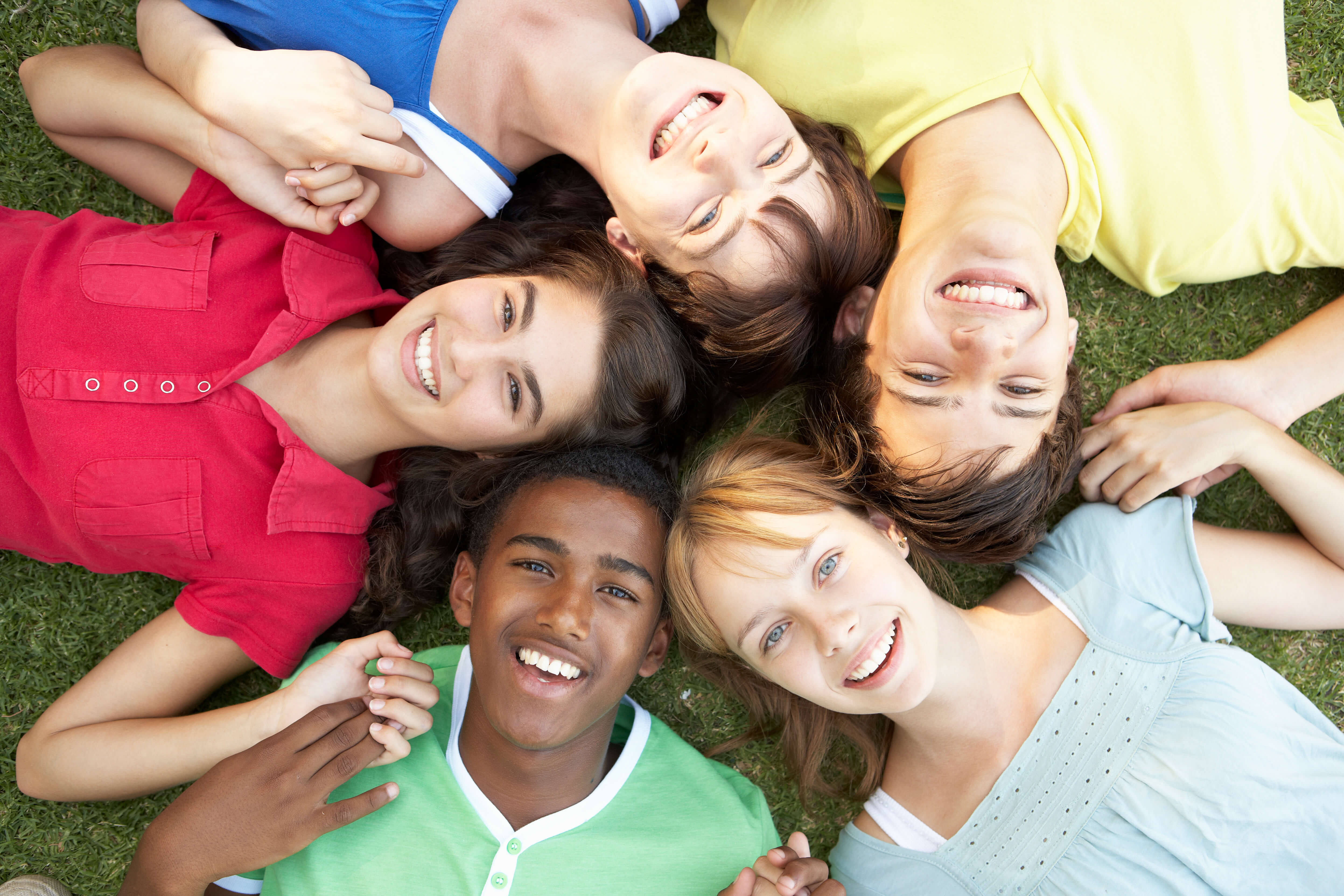 group of teenagers laying in the grass